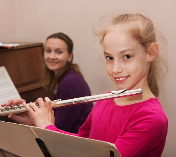 Ein junges Mädchen beim Spielen auf einer Querflöte in der Musikschule