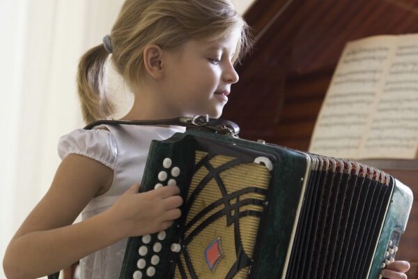 Ein Mädchen spielt Akkordeon beim Musikunterricht