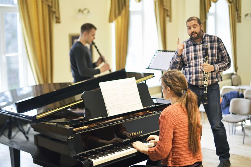 girl learns piano accompanied by clarinet