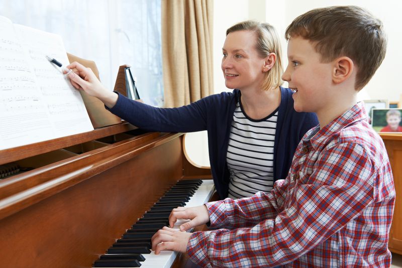 Junge am Klavier bei Klavierunterricht mit Klavierlehrerin