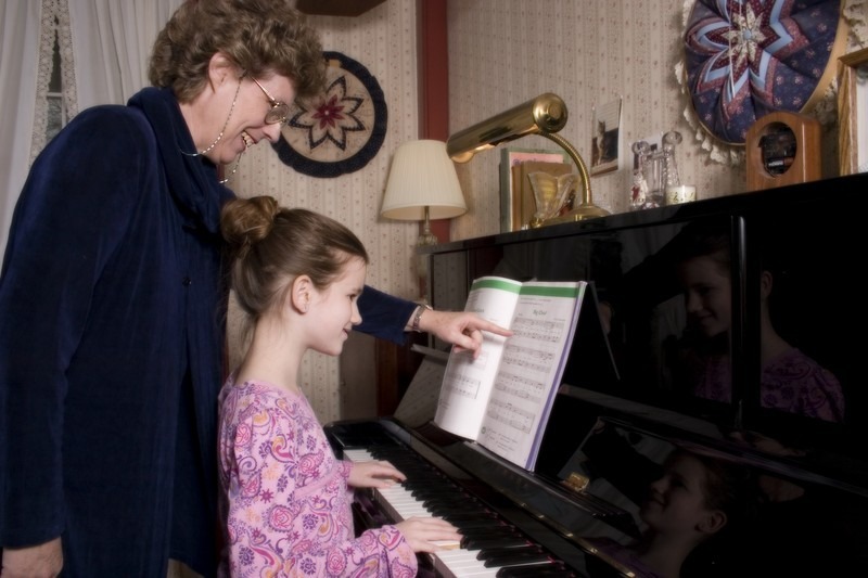 Klavierschülerin übt Klavier mit Klavierlehrerin bei Klavierunterricht zuhause